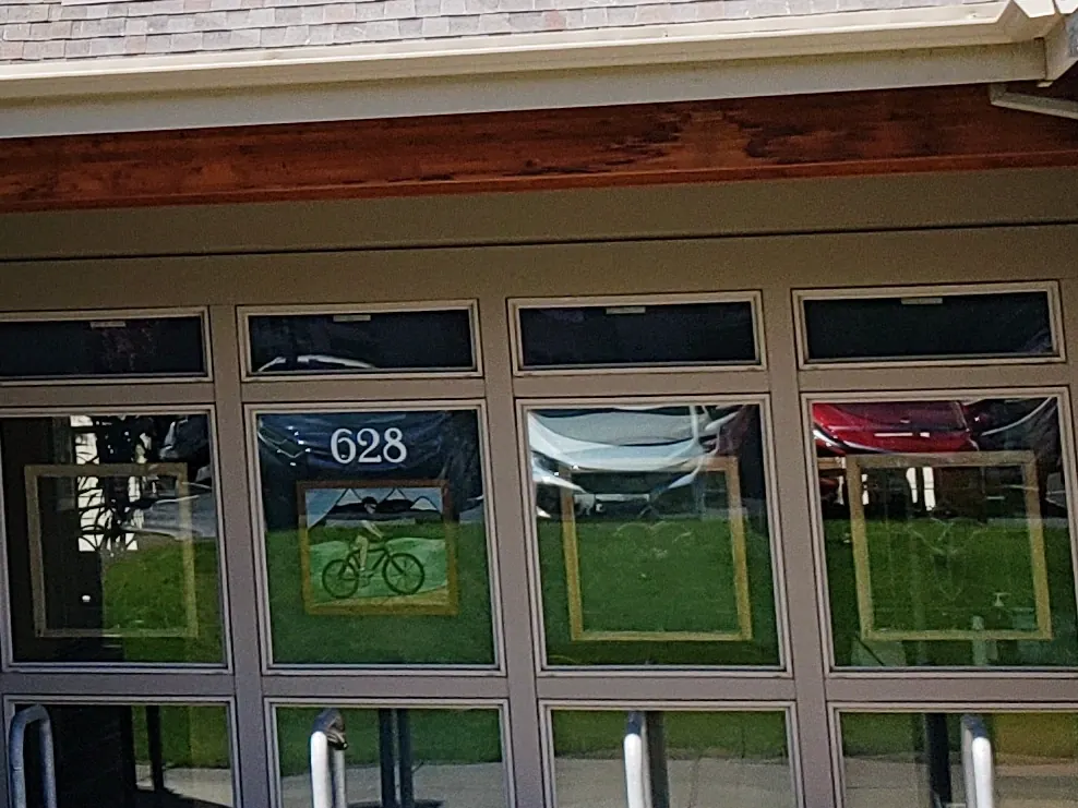 The glass entrance at 628 NW York Drive, with the number 628 and a bicycle on the window.